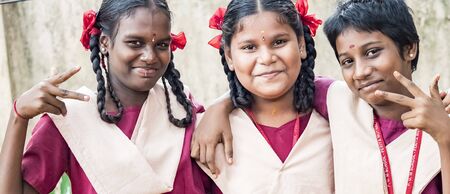 PUDUCHERRY, INDIA - DECEMBER Circa, 2018. Unidentified happy funny children friends classmates in government school uniforms smiling laughing doing victory peace sign gesture. Portrait of school teenagers enjoying friendship emotion.のeditorial素材
