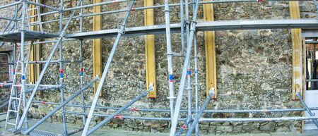 Metal girder extensive scaffolding providing platforms for stage structure support, on old stones...