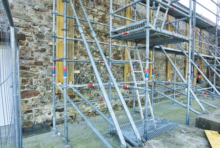 Metal girder extensive scaffolding providing platforms for stage structure support, on old stones...