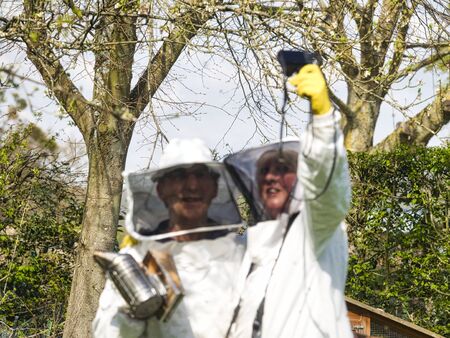 Mature woman and man beekeepers making selfie in the apiary, beekeepingの写真素材