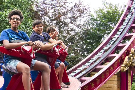 LE BOCASSE, FRANCE - AUGUST CIRCA, 2019. Unidentified children teenagers and adults sitting on disk rotating with high speed and up and down on rails. Adrenaline game in amusement park.のeditorial素材