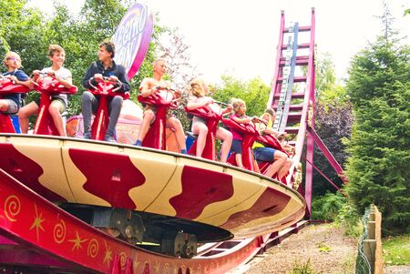 LE BOCASSE, FRANCE - AUGUST CIRCA, 2019. Unidentified children teenagers and adults sitting on disk rotating with high speed and up and down on rails. Adrenaline game in amusement park.のeditorial素材