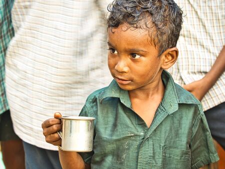PUDUCHERRY, INDIA - DECEMBER Circa, 2018. Homeless and poor child drinking milk in the streets....