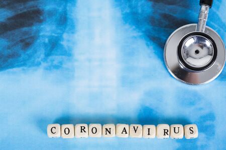 Novel Covid-19, virus concept . Text phrase Coronavirus with wooden letter on lungs radiology blue image background, with stethoscope. Copy spaceの写真素材