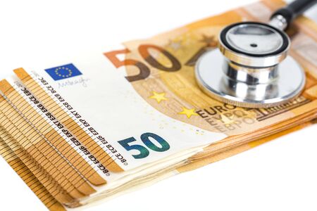 Concept of financial impact of covid-19 on European money area. Pack of fifty euros bills on white background with stethoscope on notesの写真素材
