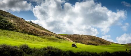 Panorama landscape of golf, with buggy and cloudy skyの写真素材