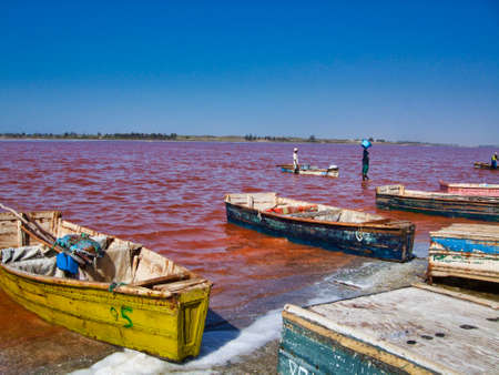 SENEGAL, AFRICA - MARSCH Circa, 2016. Unidentified Black african man and woman at Pink lake in Senegal, where farmer come to take out the salt from the sea. Very hard job. Vibrant colorsのeditorial素材