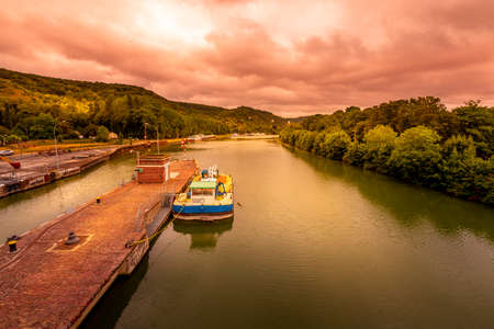 ROUEN, FRANCE - June 14, 2020. Large view by wide angle on Seine River in France, with houseboats on the river, parked. Vibrant colors, good lights, cloudy sky. Golden hourのeditorial素材