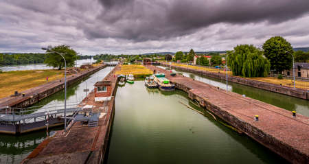 ROUEN, FRANCE - June 14, 2020. Large view by wide angle on Seine River in France, with houseboats on the river, parked. Vibrant colors, good lights, cloudy sky. Dramatic styleのeditorial素材