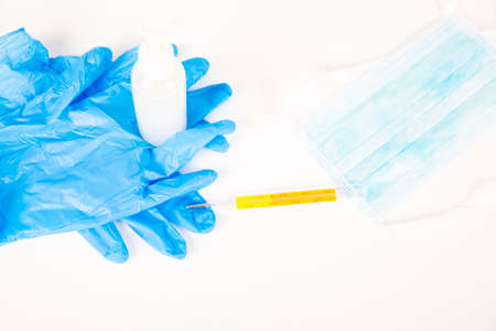 Blue gloves hand gel mask thermometer on white background. The set to use each time you go out to...
