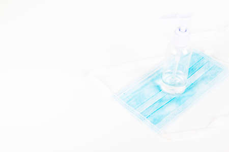 Surgey mask with alcohol gel on withe background, to stop coronavirus in the worldの写真素材