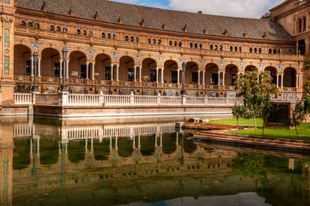 SEVILLA, SPAIN - JUNE Circa, 2020. Amazing Plaza de Espana. Water reflection of the palace buildings on the adjacent canal. One of major Spanish tourist attractions. Regionalism architecture.のeditorial素材