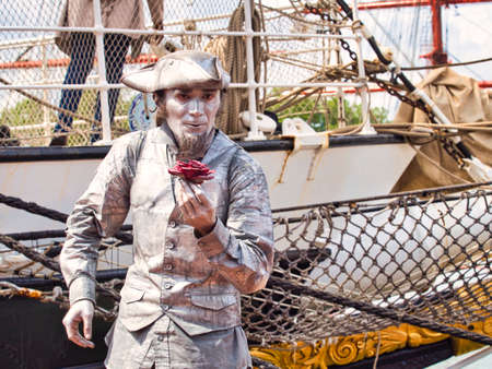 ROUEN, FRANCE - JUNE Circa, 2019. Unidentified painted mime man artist showing frozen statue on the street close to the schooner on the Rouen dock for Armada meetingのeditorial素材