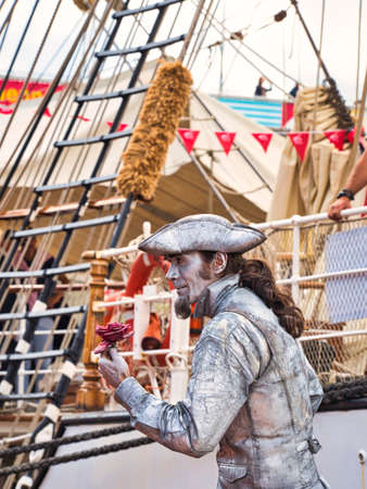ROUEN, FRANCE - JUNE Circa, 2019. Unidentified painted mime man artist showing frozen statue on the street close to the schooner on the Rouen dock for Armada meetingのeditorial素材