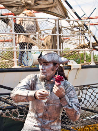 ROUEN, FRANCE - JUNE Circa, 2019. Unidentified painted mime man artist showing frozen statue on the street close to the schooner on the Rouen dock for Armada meetingのeditorial素材
