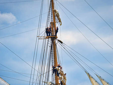 ROUEN, FRANCE - JUNE Circa, 2019. Unidentified sailors schooner standing on the top part of a mast,...