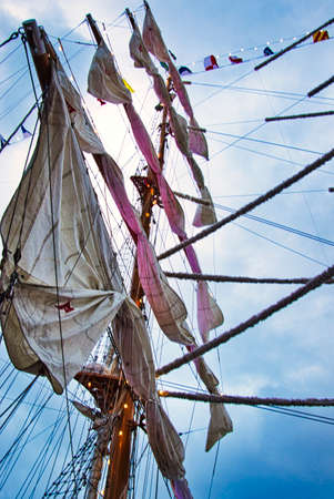 Vintage sailing ship mast ropes and tackle, Tall ship rigging mast detail, blue sky background