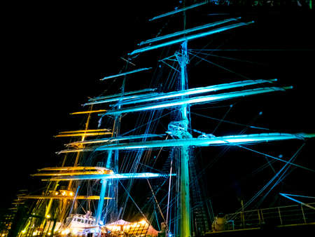 Colorful lights on masts on sailboats surrounding blurred by motion