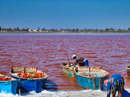 SENEGAL, AFRICA - MARSCH Circa, 2016. Unidentified Black african man and woman at Pink lake in Senegal, where farmer come to take out the salt from the sea. Very hard job. Vibrant colorsのeditorial素材