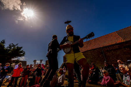 VALOGNES, FRANCE - SEPTEMBER Circa, 2020. Unidentified street musicians and performers singing and dancing outdoors. Very funny show with happy spectator. Traditional french music on public event.のeditorial素材