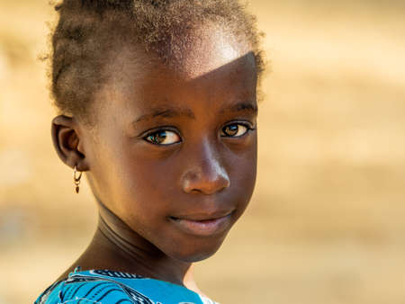 MBOUR, SENEGAL - JANUARY Circa, 2021. Portrait of unidentified young senegalese children, looking at camera. Beautiful skin, hairs, light. outdoorsのeditorial素材