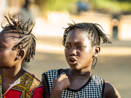 MBOUR, SENEGAL - JANUARY Circa, 2021. Portrait of unidentified young senegalese children, not looking at camera. Beautiful skin, hairs, light. outdoorsのeditorial素材