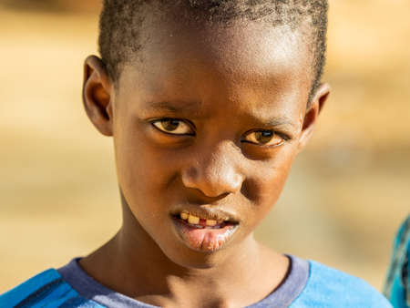 MBOUR, SENEGAL - JANUARY Circa, 2021. Unidentified child boy with sad anxious face, thinking about...