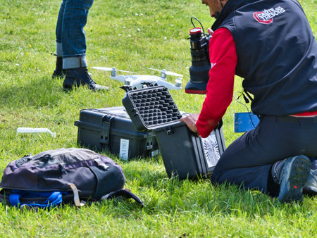 JUMIEGES, FRANCE - JUNE Circa, 2019. Mature male technicians outdoor, on grass, using professional...