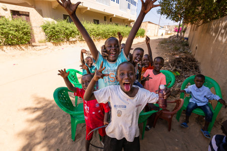 MBOUR, SENEGAL - CIRCA MARCH 2021. Unidentified group of happy smiling poor african children and teenagers looking at camera.のeditorial素材