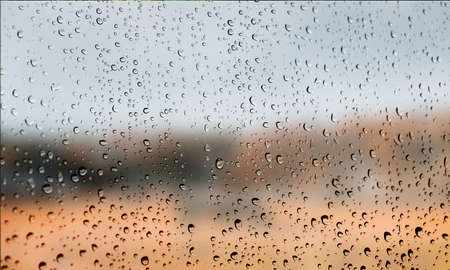 Background with rain drops close up. Rain drops on outdoor window, Closeup view transparent water drops on glass surface, humid water backdrop, blurred background with copy space for your textの写真素材