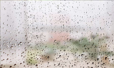 Background with rain drops close up. Rain drops on outdoor window, Closeup view transparent water drops on glass surface, humid water backdrop, blurred background with copy space for your textの写真素材