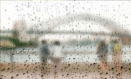 Background with rain drops close up. Rain drops on outdoor window, Closeup view transparent water drops on glass surface, humid water backdrop, blurred background with copy space for your textの写真素材