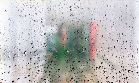 Background with rain drops close up. Rain drops on outdoor window, Closeup view transparent water drops on glass surface, humid water backdrop, blurred background with copy space for your textの写真素材