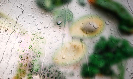 Background with rain drops close up. Rain drops on outdoor window, Closeup view transparent water drops on glass surface, humid water backdrop, blurred background with copy space for your textの写真素材