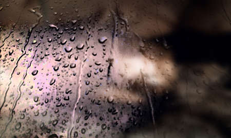 Background with rain drops close up. Rain drops on outdoor window, Closeup view transparent water drops on glass surface, humid water backdrop, blurred background with copy space for your textの写真素材