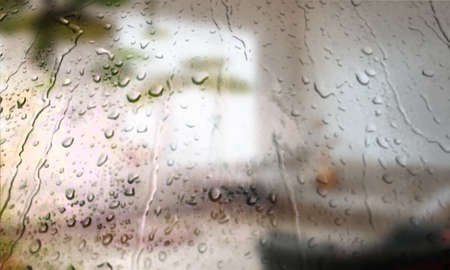 Background with rain drops close up. Rain drops on outdoor window, Closeup view transparent water drops on glass surface, humid water backdrop, blurred background with copy space for your textの写真素材