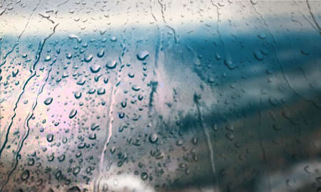 Background with rain drops close up. Rain drops on outdoor window, Closeup view transparent water drops on glass surface, humid water backdrop, blurred background with copy space for your textの写真素材
