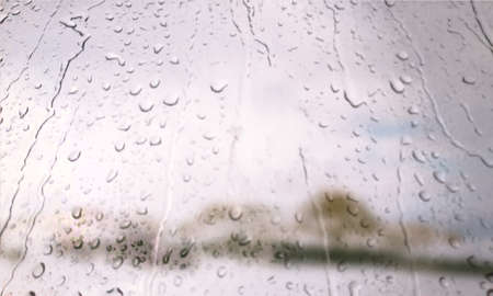 Background with rain drops close up. Rain drops on outdoor window, Closeup view transparent water drops on glass surface, humid water backdrop, blurred background with copy space for your textの写真素材