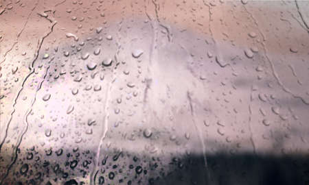 Background with rain drops close up. Rain drops on outdoor window, Closeup view transparent water drops on glass surface, humid water backdrop, blurred background with copy space for your textの写真素材