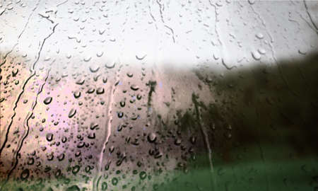 Background with rain drops close up. Rain drops on outdoor window, Closeup view transparent water drops on glass surface, humid water backdrop, blurred background with copy space for your textの写真素材
