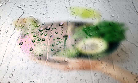 Background with rain drops close up. Rain drops on outdoor window, Closeup view transparent water drops on glass surface, humid water backdrop, blurred background with copy space for your textの写真素材
