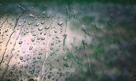 Background with rain drops close up. Rain drops on outdoor window, Closeup view transparent water drops on glass surface, humid water backdrop, blurred background with copy space for your textの写真素材