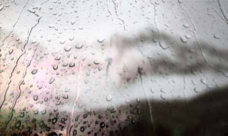 Background with rain drops close up. Rain drops on outdoor window, Closeup view transparent water drops on glass surface, humid water backdrop, blurred background with copy space for your textの写真素材