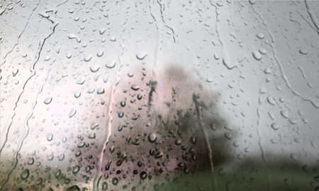 Background with rain drops close up. Rain drops on outdoor window, Closeup view transparent water drops on glass surface, humid water backdrop, blurred background with copy space for your textの写真素材