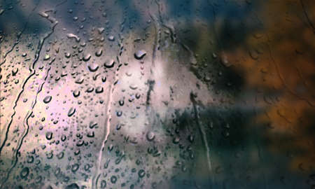 Background with rain drops close up. Rain drops on outdoor window, Closeup view transparent water drops on glass surface, humid water backdrop, blurred background with copy space for your textの写真素材