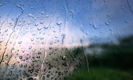Background with rain drops close up. Rain drops on outdoor window, Closeup view transparent water drops on glass surface, humid water backdrop, blurred background with copy space for your textの写真素材