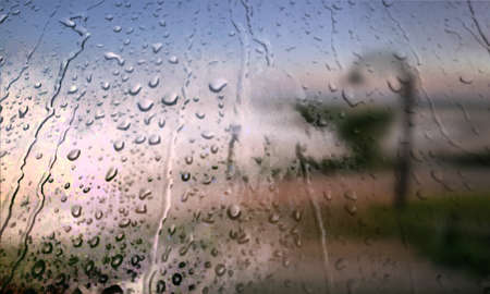 Background with rain drops close up. Rain drops on outdoor window, Closeup view transparent water drops on glass surface, humid water backdrop, blurred background with copy space for your textの写真素材