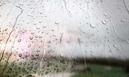 Background with rain drops close up. Rain drops on outdoor window, Closeup view transparent water drops on glass surface, humid water backdrop, blurred background with copy space for your textの写真素材