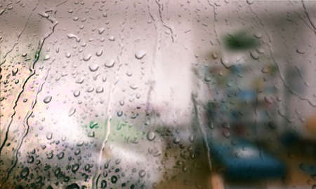 Background with rain drops close up. Rain drops on outdoor window, Closeup view transparent water drops on glass surface, humid water backdrop, blurred background with copy space for your textの写真素材