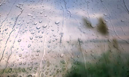 Background with rain drops close up. Rain drops on outdoor window, Closeup view transparent water drops on glass surface, humid water backdrop, blurred background with copy space for your textの写真素材